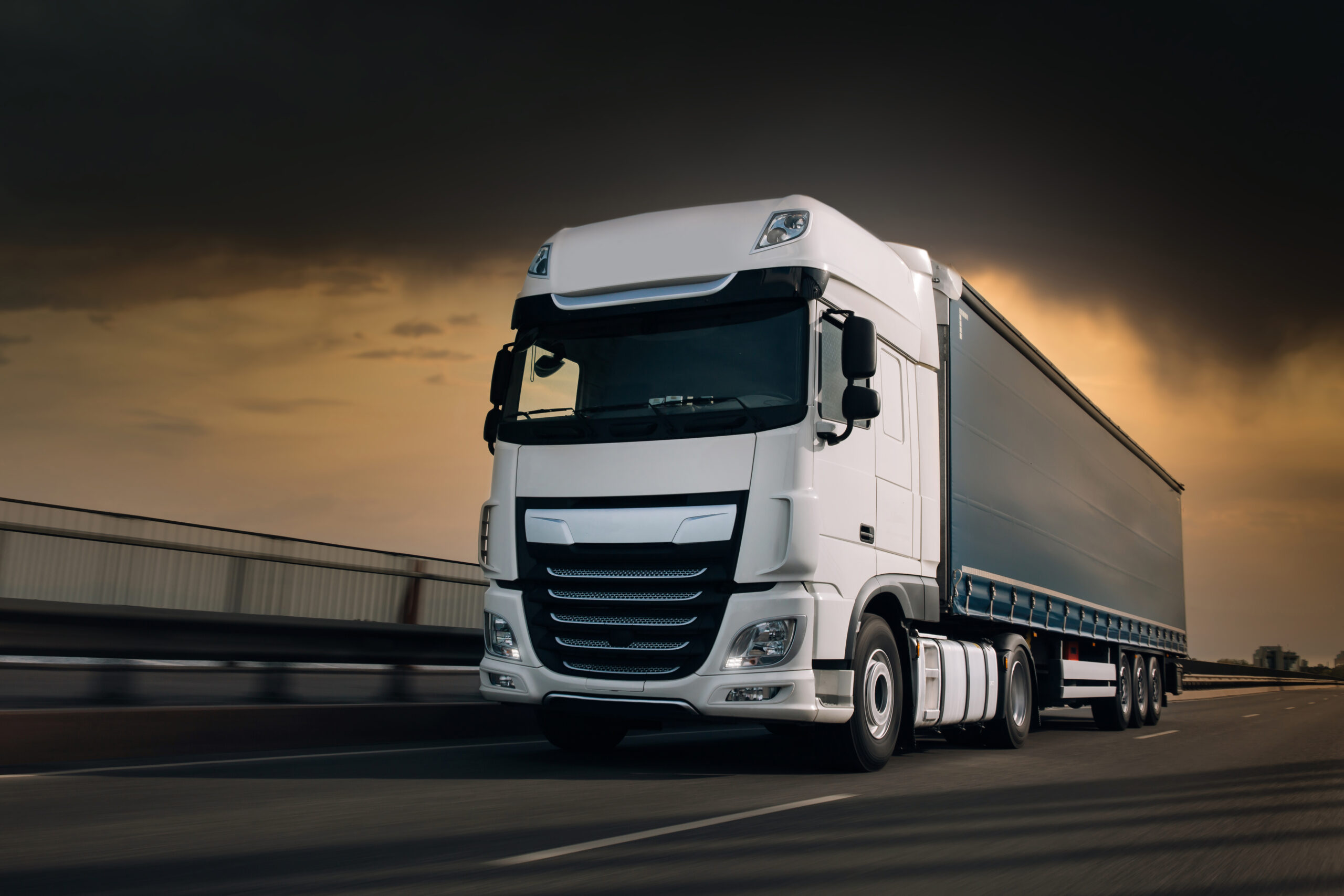 Semi-truck with cargo trailer driving at the hightway. Fast movi